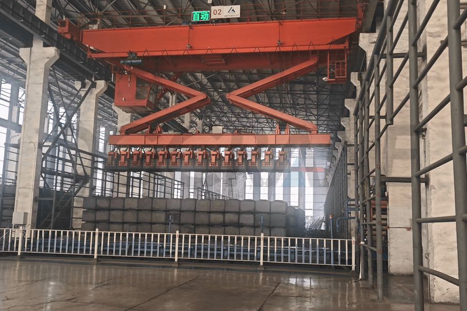 Mostový jeřáb pro stohování anodových uhlíkových bloků používaný v průmyslu elektrolýzy hliníku